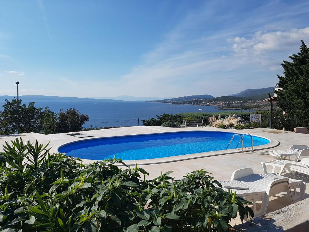 una piscina con sillas y vistas al océano en Villa Marlin en Klenovica