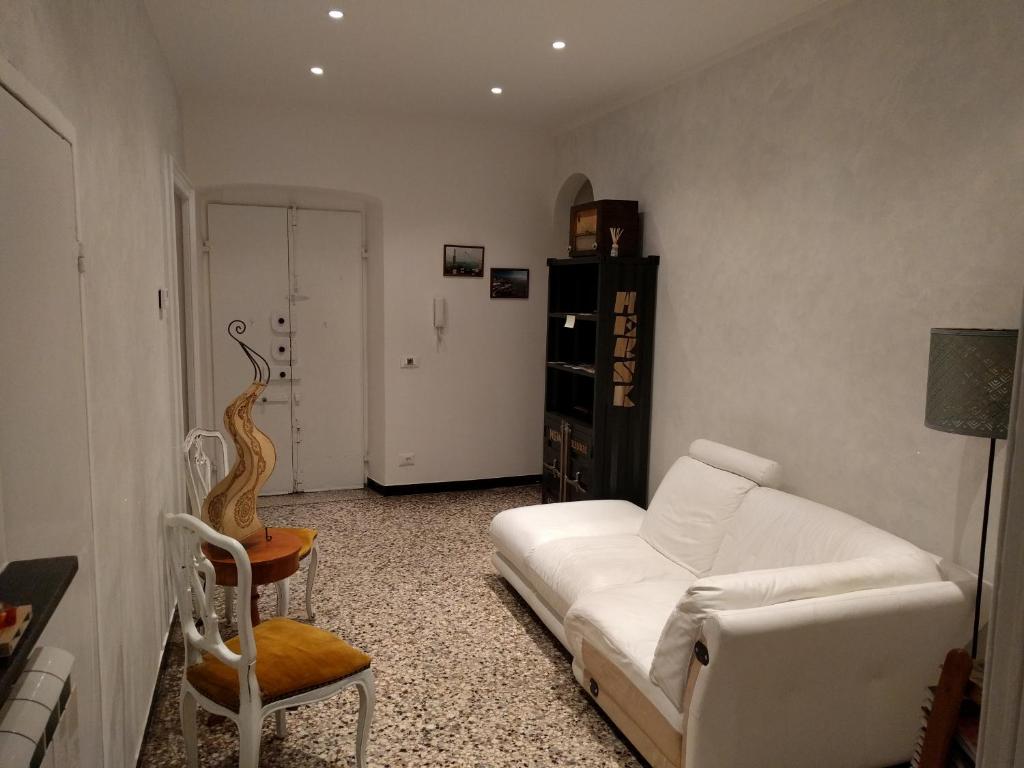 B&B Al Fronte del Porto في جينوا: غرفة معيشة مع أريكة بيضاء وكرسي