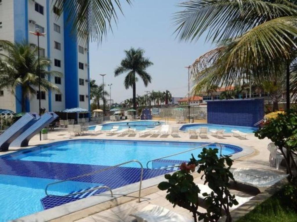 una gran piscina con sillas y un edificio en Aguas da Serra - Achei Ferias, en Caldas Novas