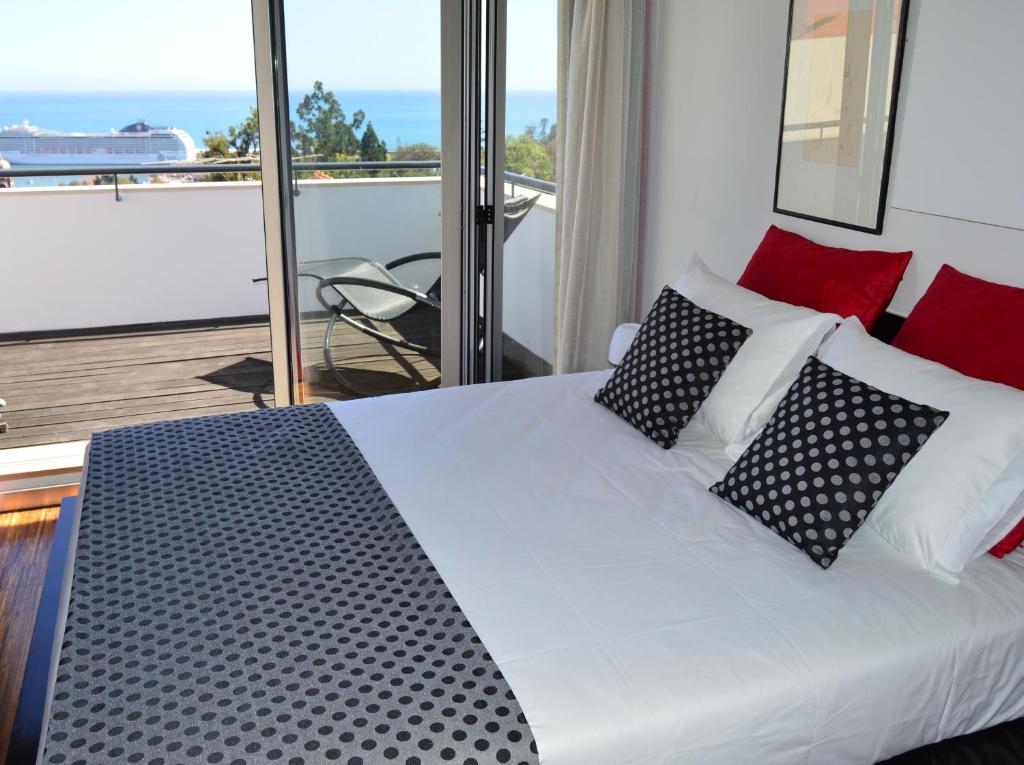 a bedroom with a bed with black and white pillows at vista dos arrifes in Funchal