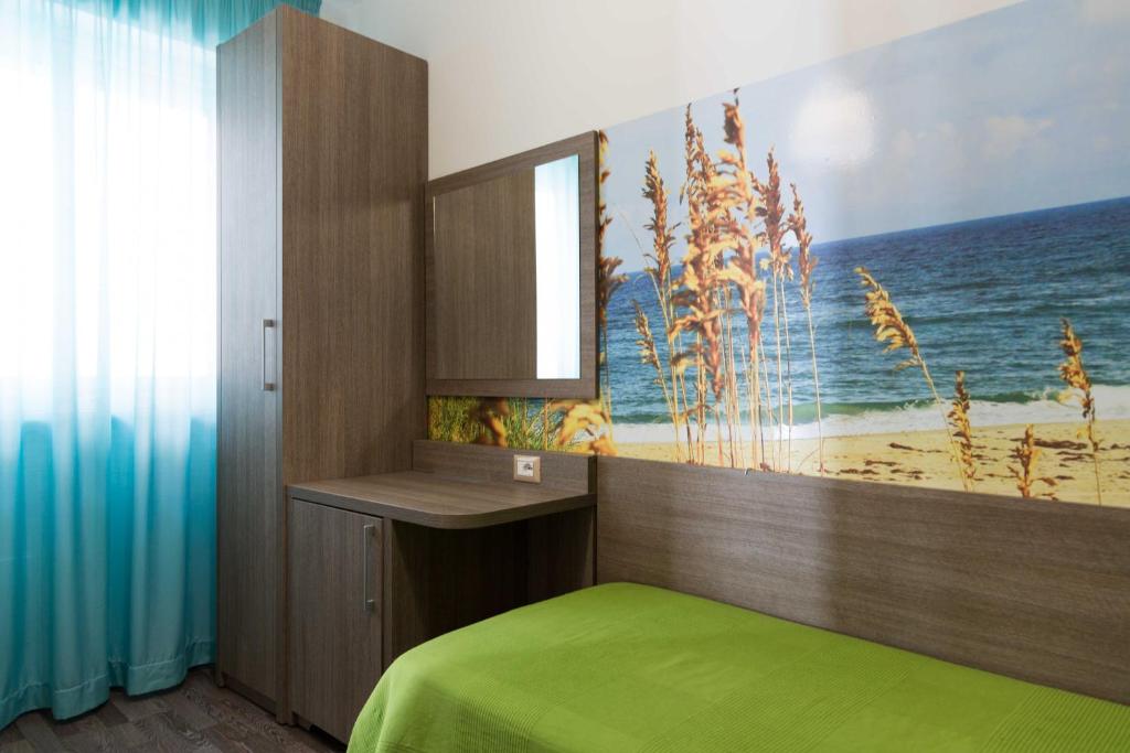 a bedroom with a bed and a painting of the ocean at Hotel Miramare in Pineto