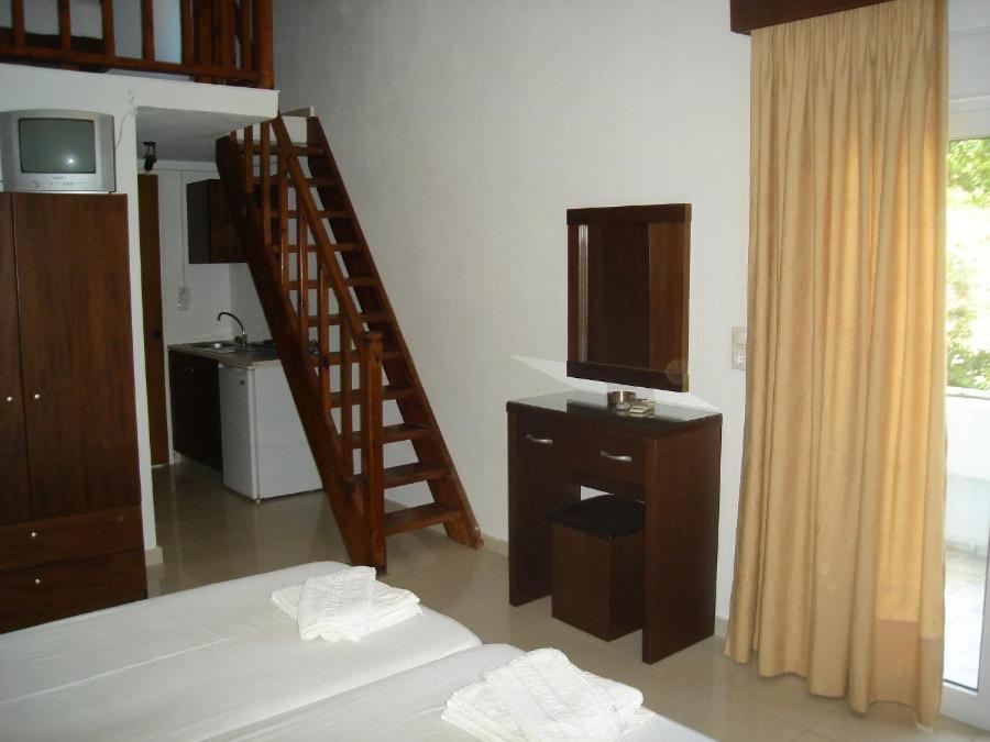 a room with a bedroom with a bed and a television at Hotel Zachos in Troulos