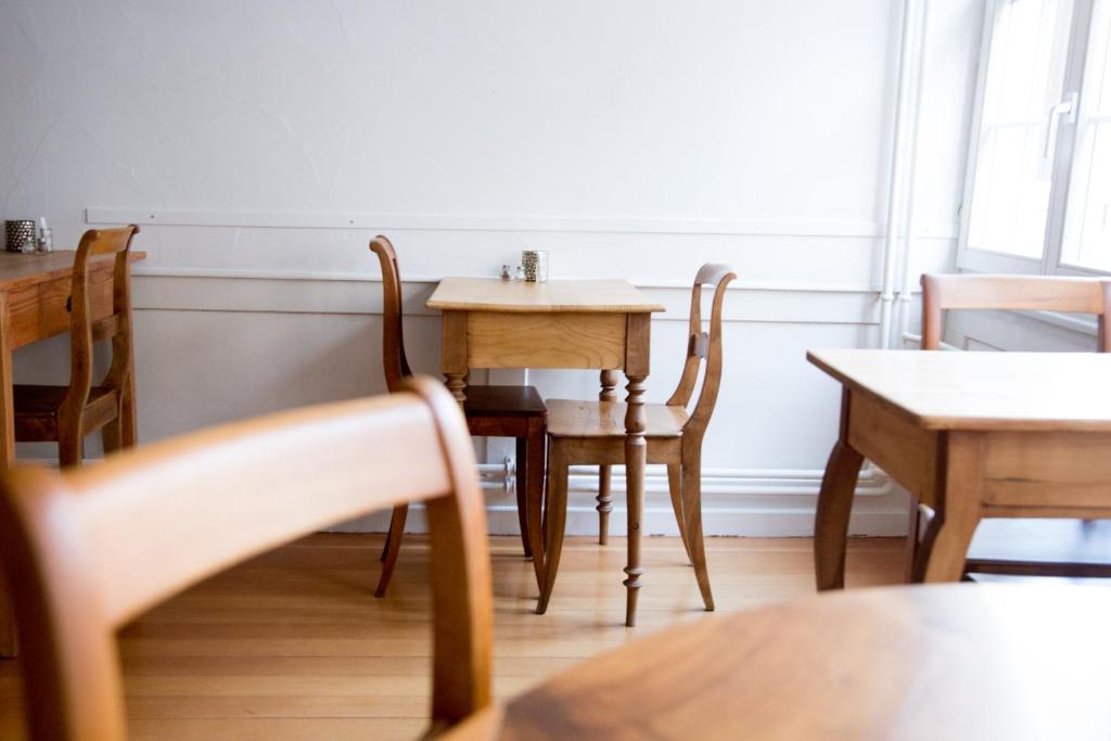 una sala da pranzo con tavoli e sedie in legno di Bett am Weiher a Wil