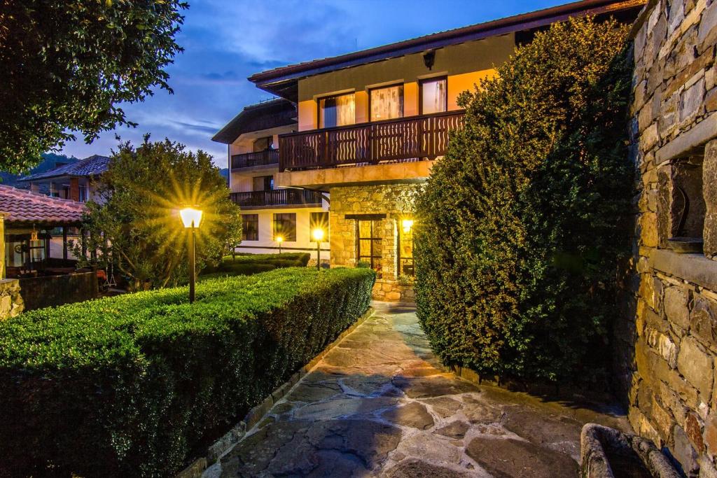a house with a walkway in front of a building at Guesthouse Hitar Petar in Gabrovo