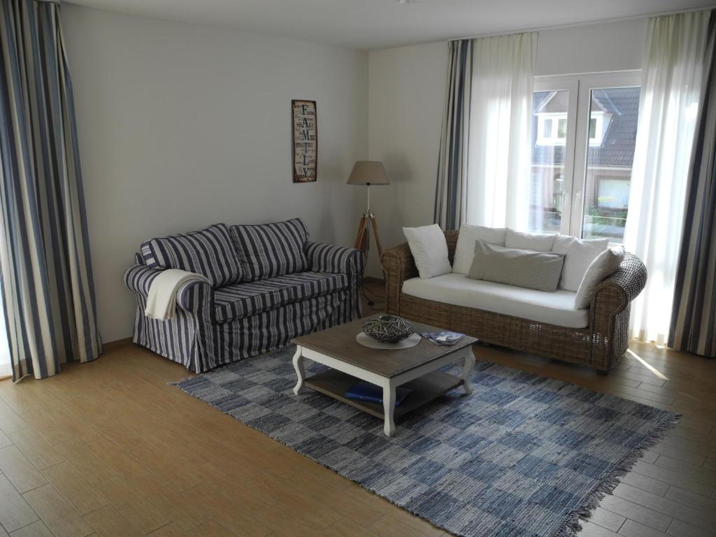Una sala de estar con dos sofás y una mesa de café. en SEASIDE APARTMENTS - SUNNY BLUE, en Eckernförde