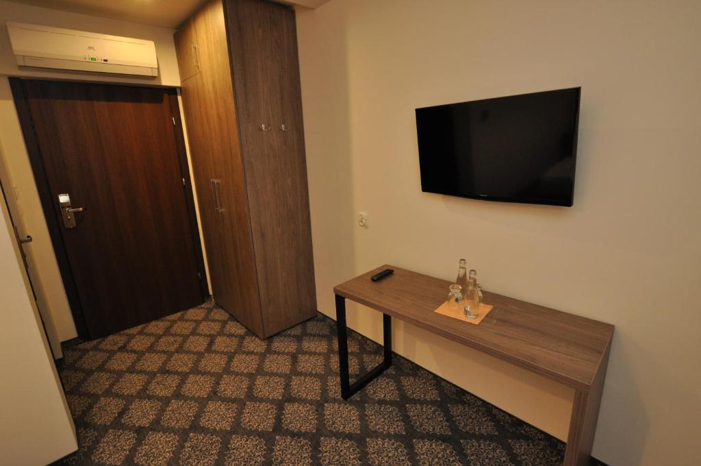 Televízia a/alebo spoločenská miestnosť v ubytovaní Pass Hotel