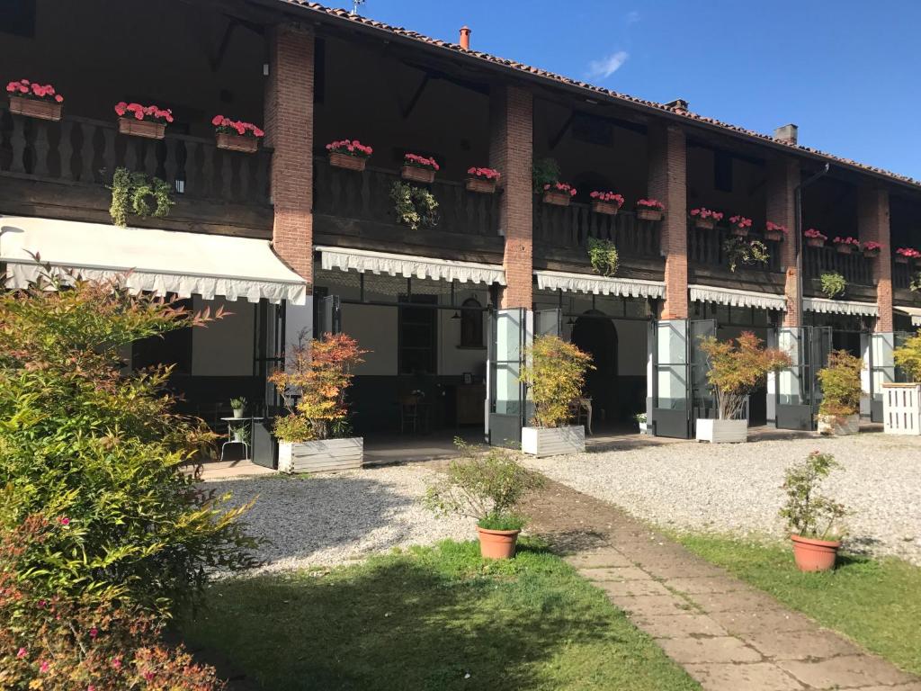 a large brick building with potted plants in the courtyard at Agriturismo Cascina Magana in Burago di Molgora