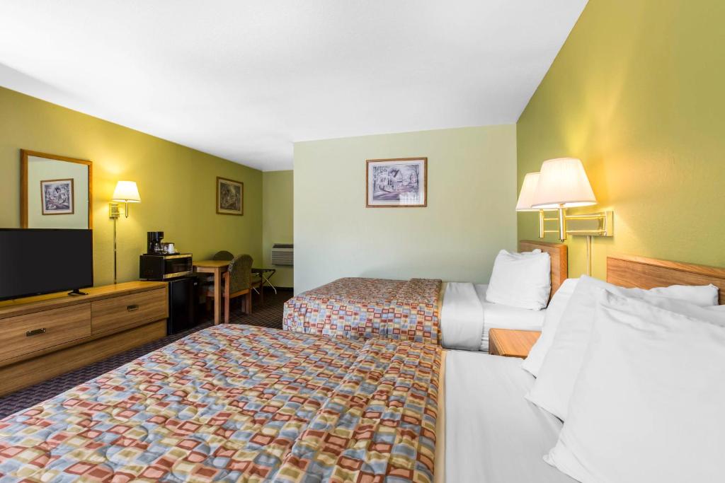 a hotel room with two beds and a flat screen tv at Rodeway Inn Gunnison in Gunnison
