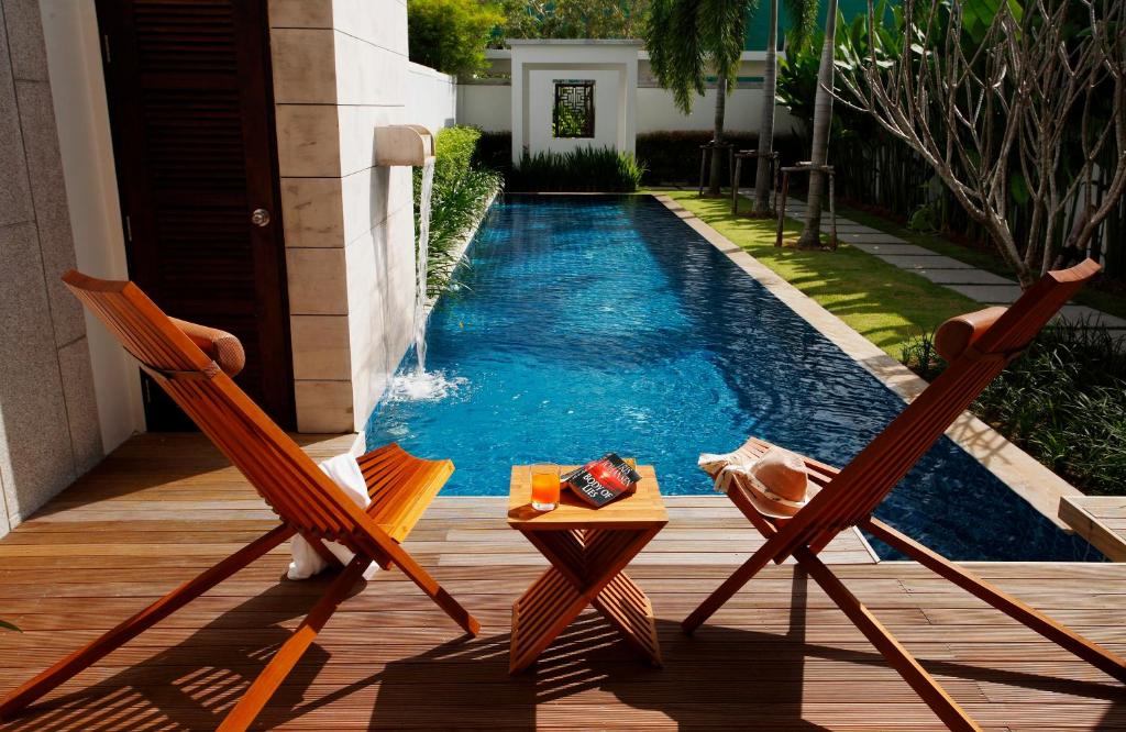 dwa krzesła i stół obok basenu w obiekcie Two Villas HOLIDAY - Oxygen Style Bang Tao Beach w mieście Bang Tao Beach
