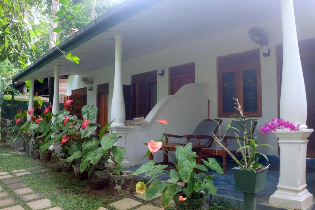 una casa blanca con plantas delante en Sansala Guesthouse & Restaurant, en Tangalle