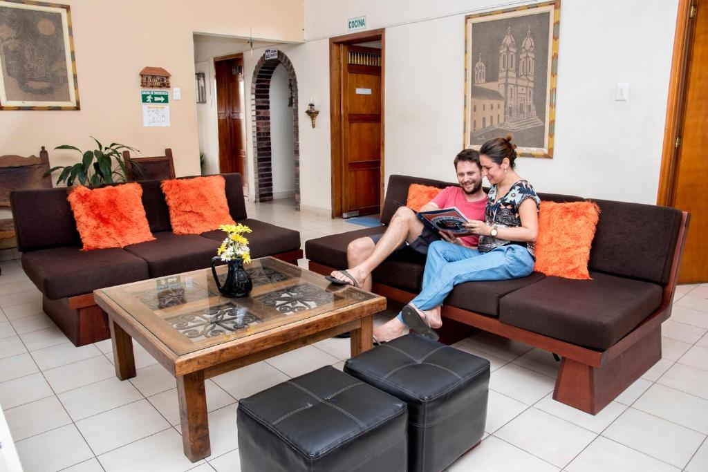 two people sitting on couches in a living room at Macondo Hostel in San Gil