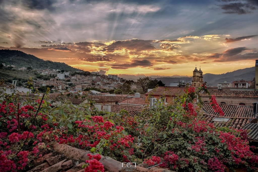 a view of a city at sunset with flowers at Macondo Hostel in San Gil