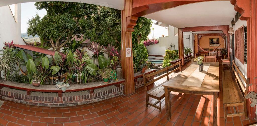 a balcony with a table and a bunch of plants at Macondo Hostel in San Gil