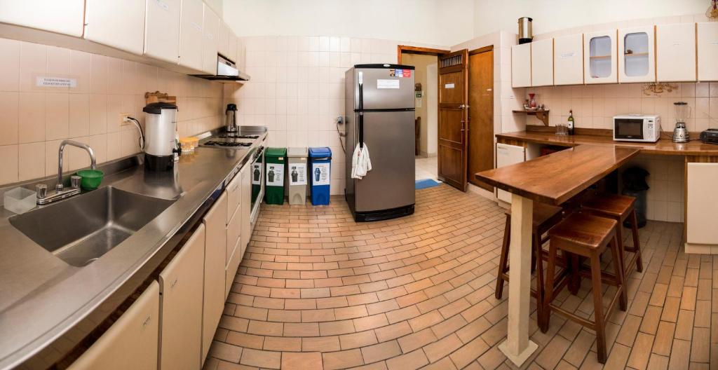 a kitchen with a refrigerator and a table in it at Macondo Hostel in San Gil