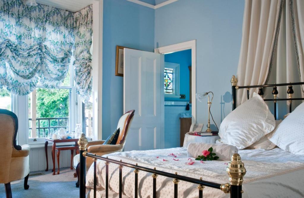 sypialnia z łóżkiem z niebieskimi ścianami i oknem w obiekcie Burnbank w mieście Berwick