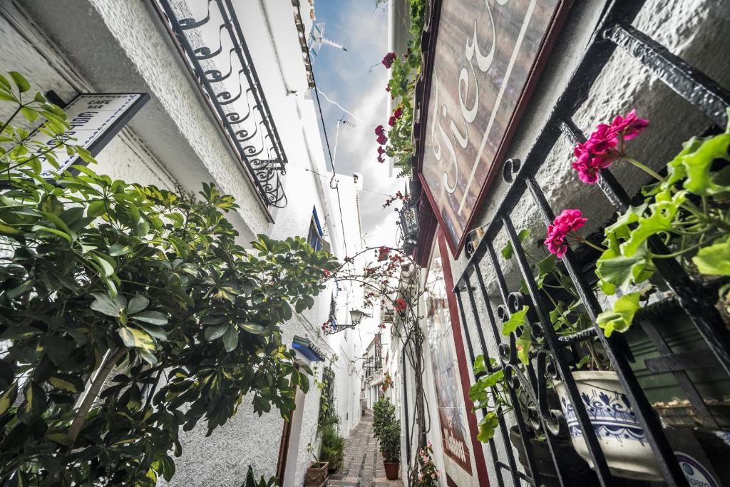 an alley with flowers and plants in a building at Óbal Hotel Marbella in Marbella