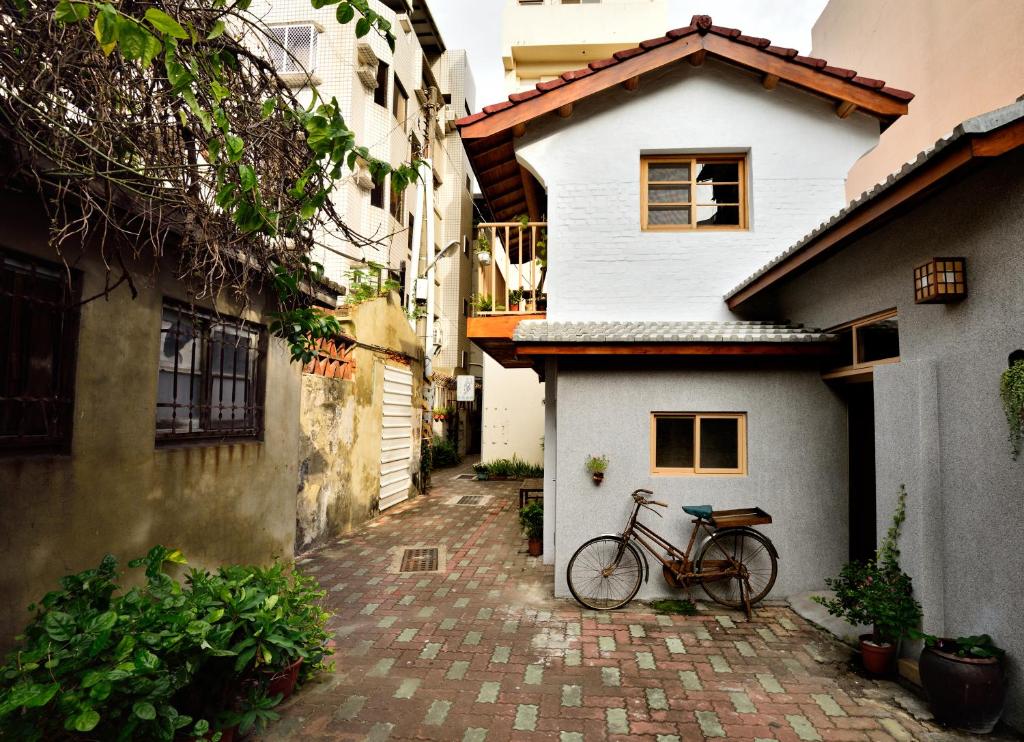 台南的住宿－永福97.1，一辆自行车停在白色房子旁边
