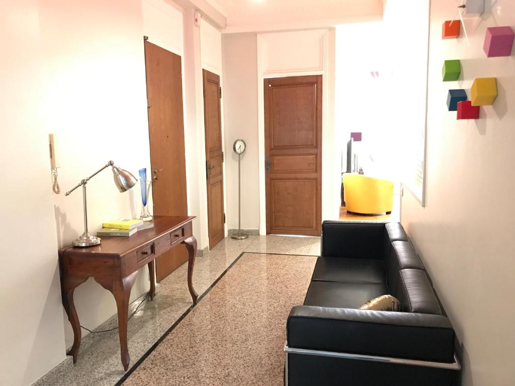 sala de estar con sofá de cuero negro y escritorio en Palais Haydee, en Niza
