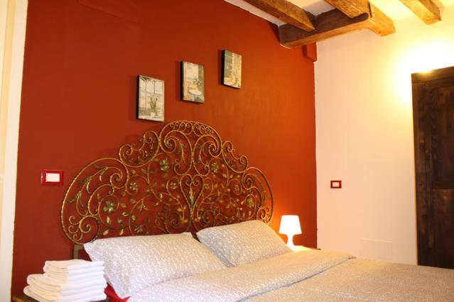a bed in a room with an orange wall at Salizada San Francesco in Venice
