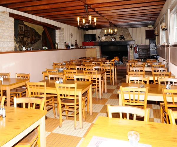 a restaurant filled with wooden tables and chairs at Hotel Restaurant Maurice in Châteauroux
