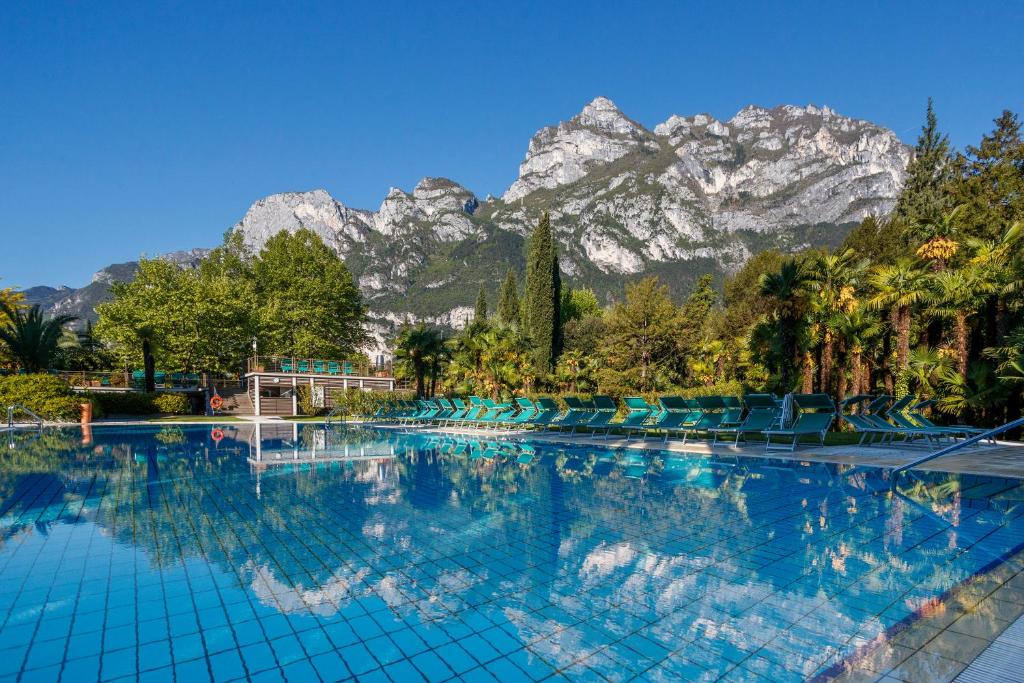 a swimming pool with mountains in the background at Du Lac Et Du Parc Grand Resort in Riva del Garda