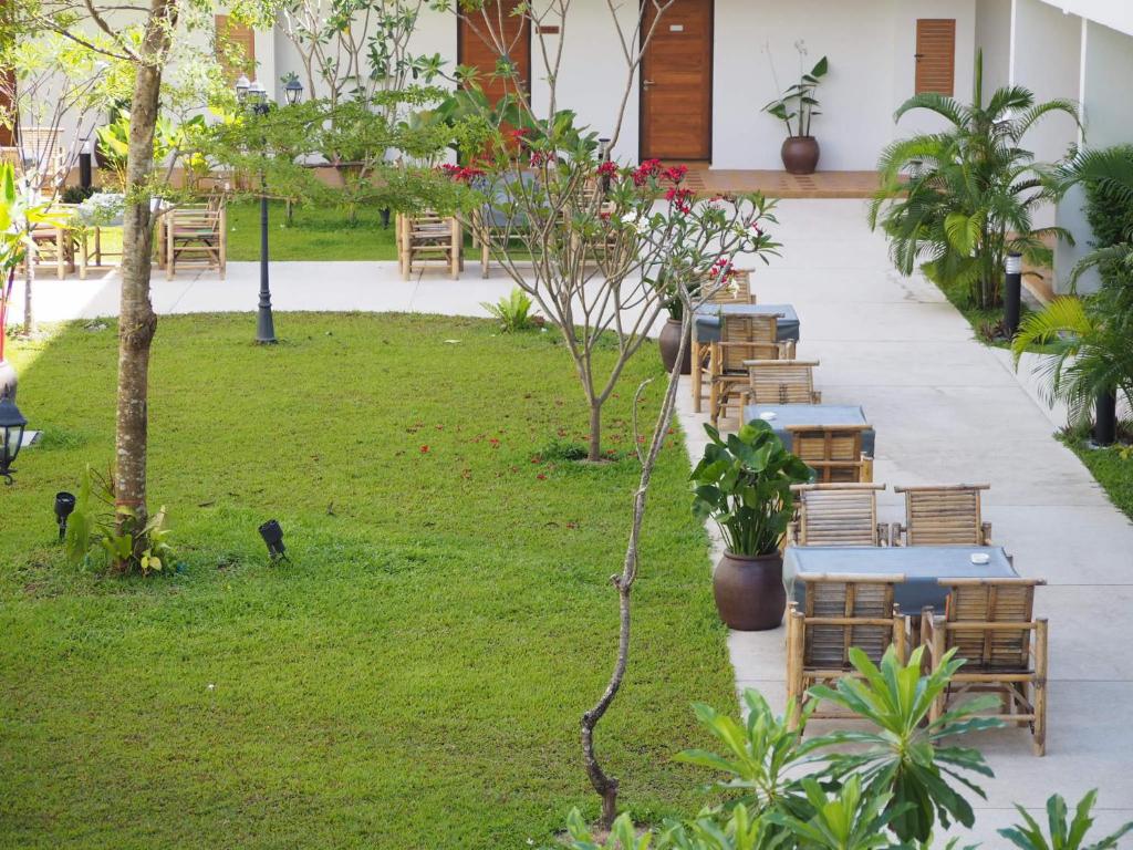 a row of tables and chairs in a garden at Crystal Lamai Hotel in Lamai