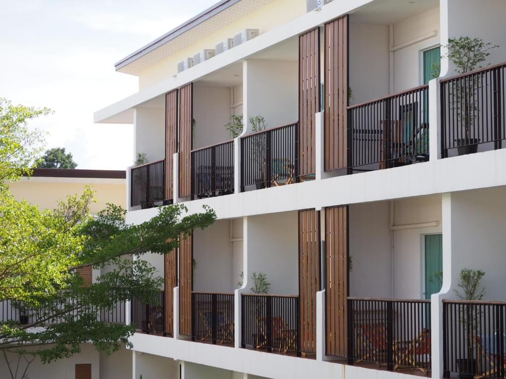 an apartment building with balconies and trees at Crystal Lamai Hotel in Lamai
