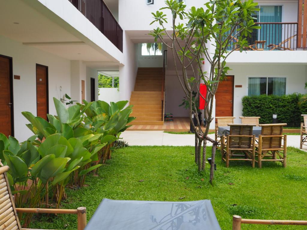 a patio with a table and chairs in a yard at Crystal Lamai Hotel in Lamai