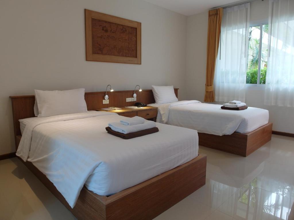 a bedroom with two beds with white sheets and a window at Crystal Lamai Hotel in Lamai