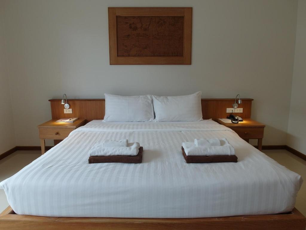 a large white bed with two towels on it at Crystal Lamai Hotel in Lamai