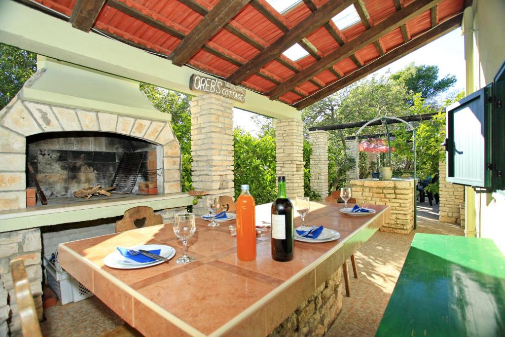 a patio with a table and a fireplace at Stone House Oreb`s Cottage in Vela Luka