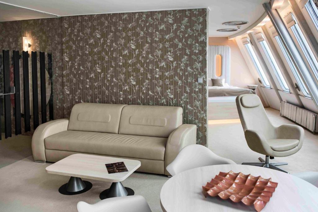 a living room with a couch and a bed at Hotel Ještěd in Liberec