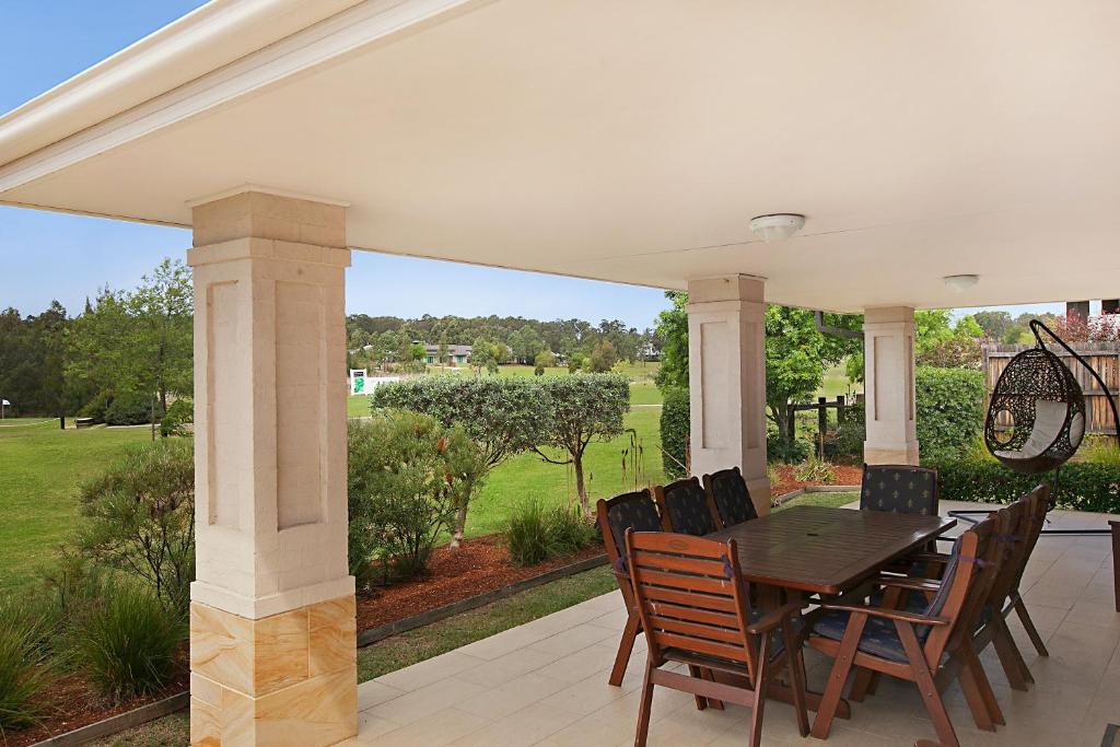 une terrasse couverte avec une table et des chaises. dans l'établissement Peppertree Lodge Hunter Valley, à Rothbury