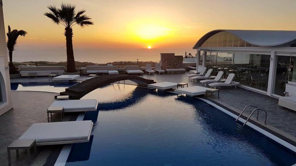 una piscina in un edificio con un tramonto sullo sfondo di Blue Suites a Firà