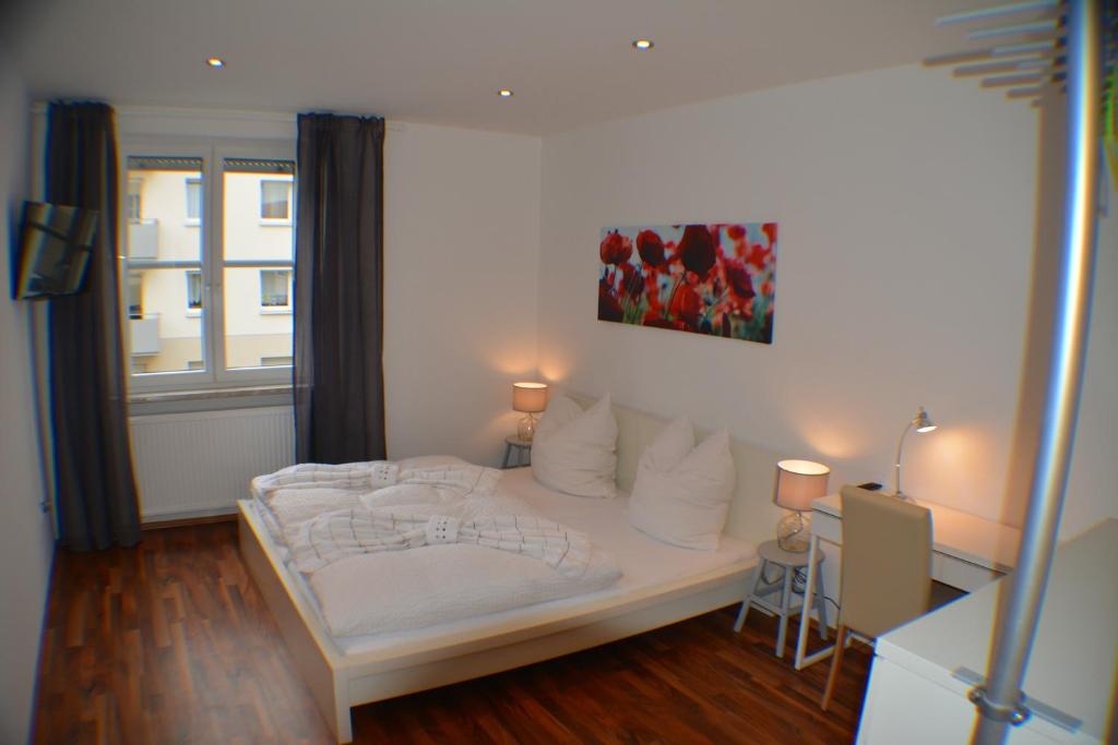 a bedroom with a white bed and a window at Apartment Avenzio in Würzburg
