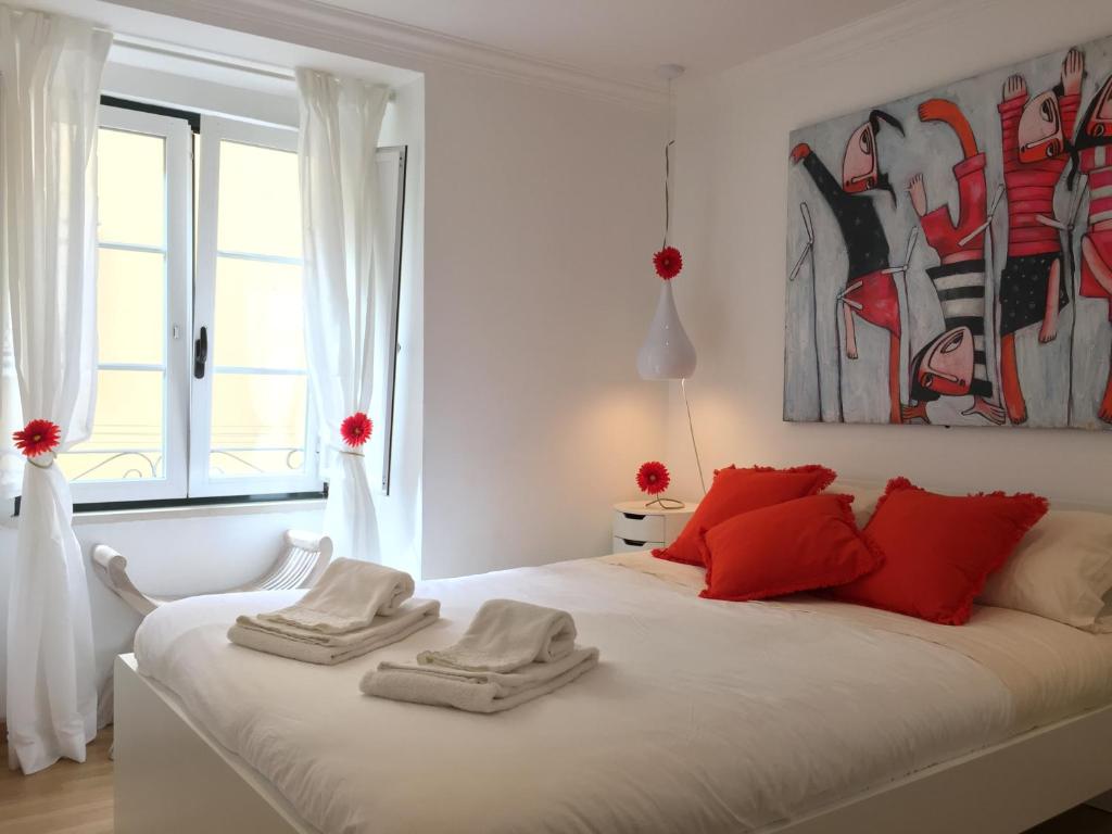 リスボンにあるAlfamaSweethome 2の白いベッドルーム(赤い枕のベッド付)