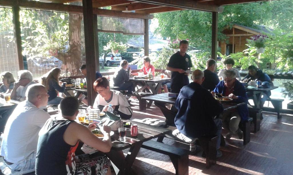 a group of people sitting at tables in a restaurant at Camping Matyáš in Vrané nad Vltavou