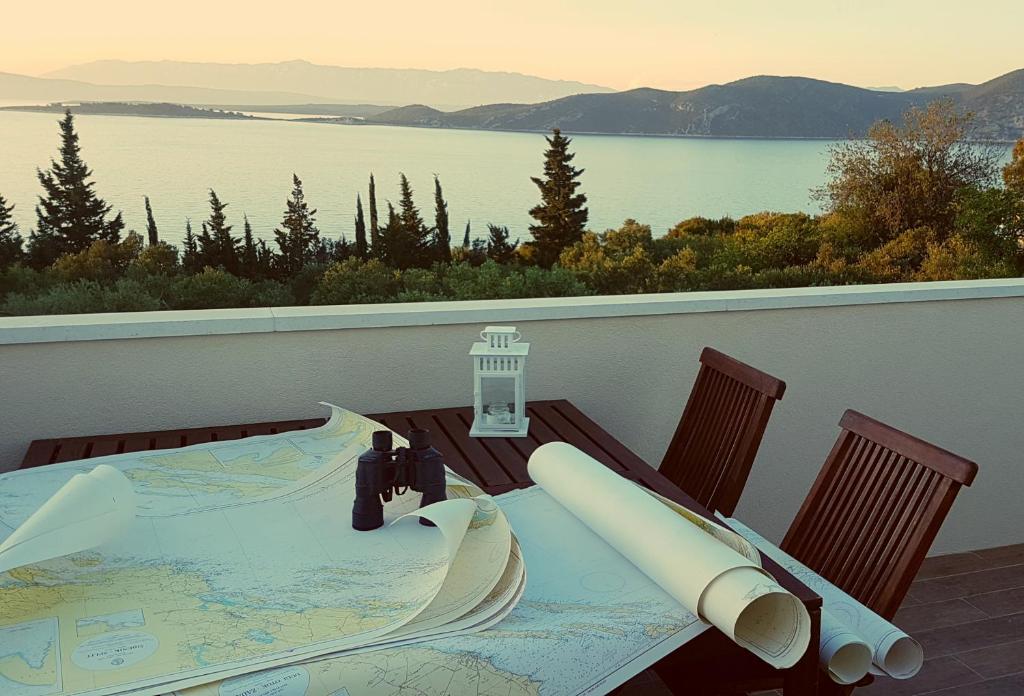 a table on a balcony with a view of the water at Captain's Attic in Račišće
