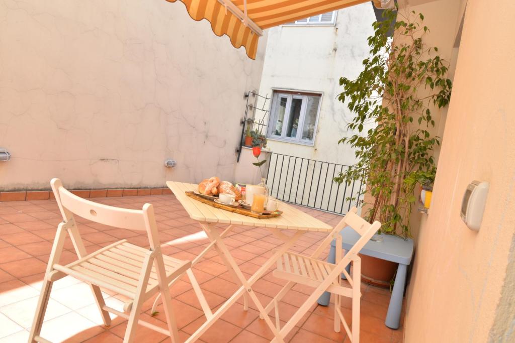 un patio con mesa y 2 sillas en Casa Lungomare, en Salerno