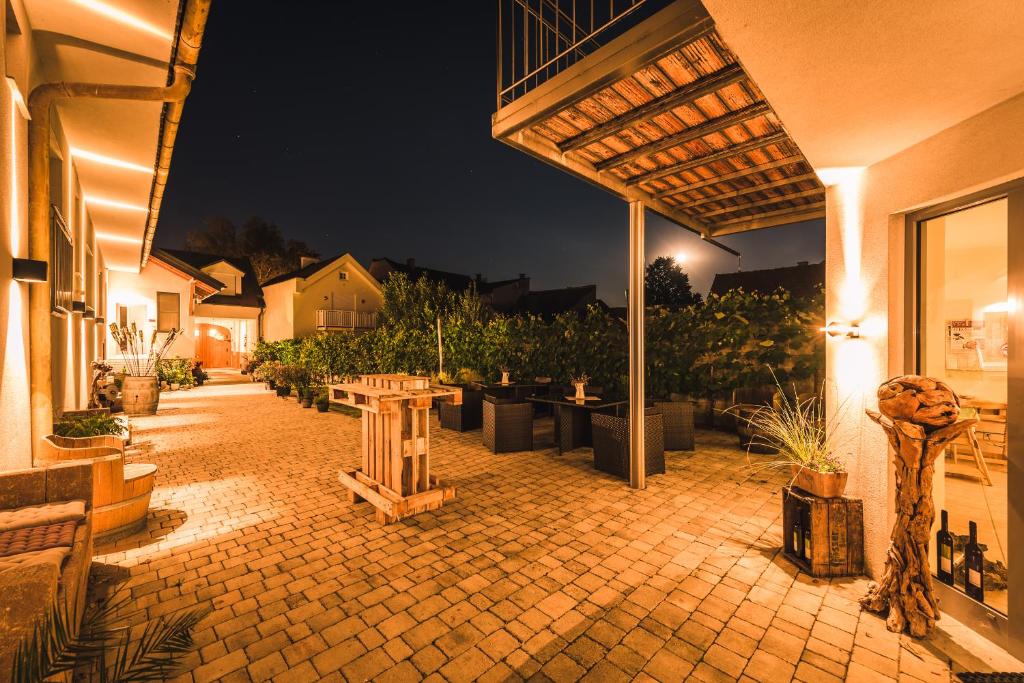 un patio al aire libre por la noche con una mesa y bancos en Weingut Gästehaus D&D Haider, en Jois