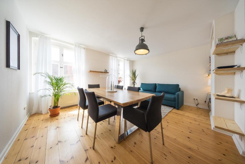 een eetkamer met een tafel en stoelen en een bank bij Design Apartments - "Potsdam City" 18 in Potsdam