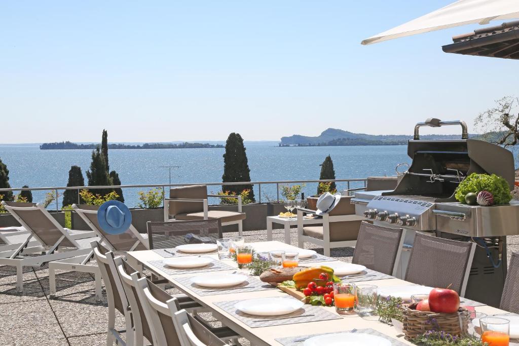 een tafel met borden en een grill op een patio bij Villa Elvira in Gardone Riviera