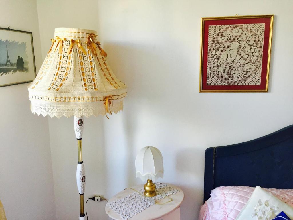 una lámpara en un dormitorio junto a una cama en Casa Spilla, en Caltanissetta