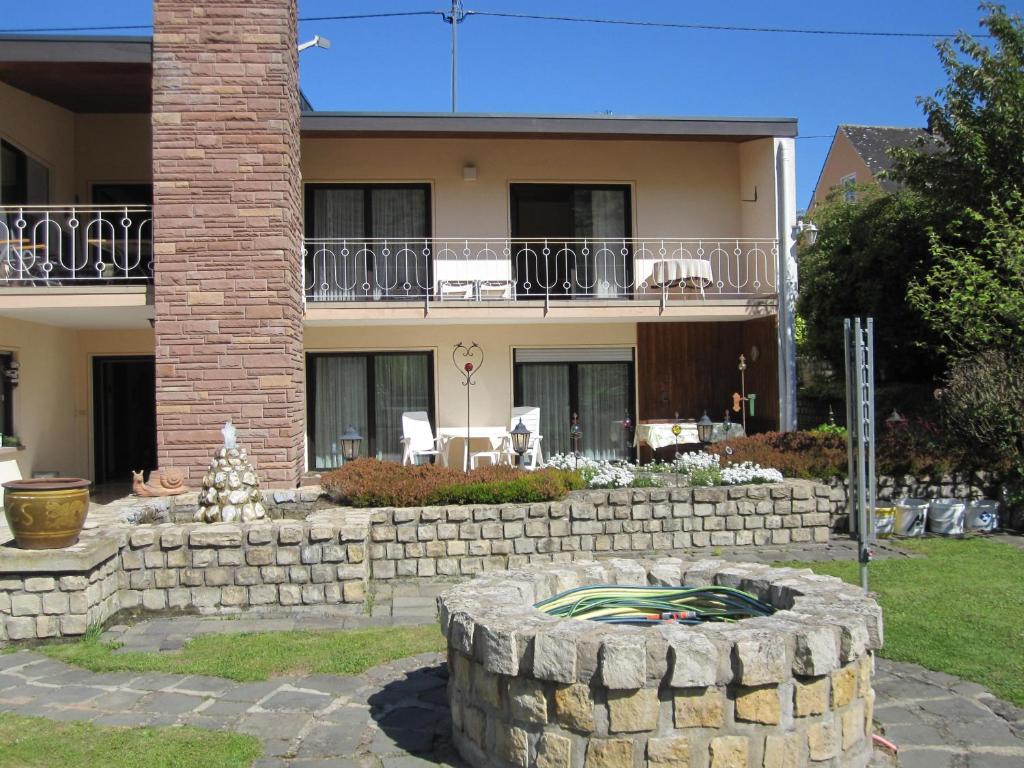 ein Haus mit einer Steinmauer vor einem Hof in der Unterkunft Elisabeth Decker in Zeltingen-Rachtig