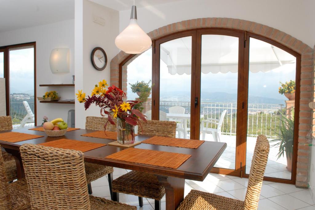 comedor con mesa de madera y sillas en Villa Vista Mare en Casal Velino