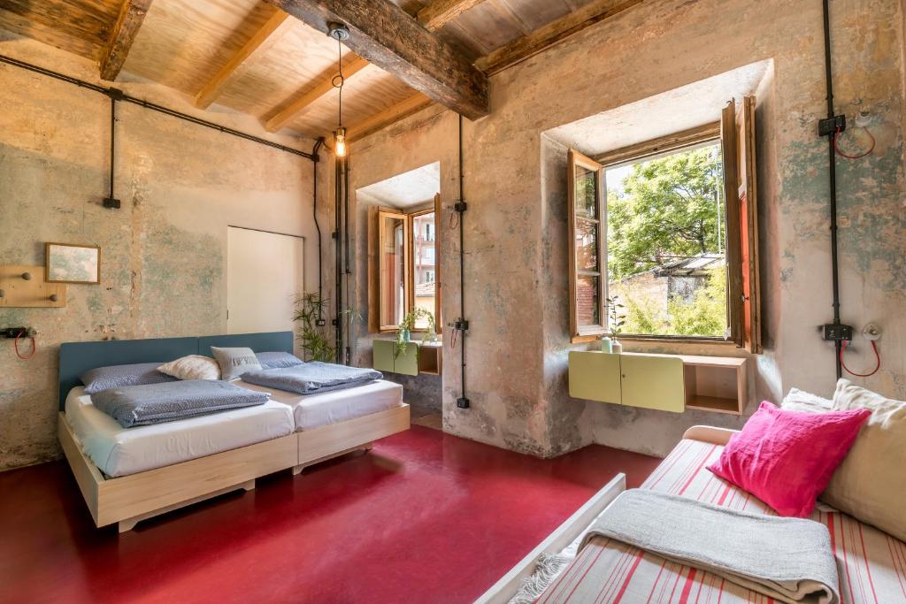 1 dormitorio con 2 camas y ventana en Un posto a Milano - guesthouse all'interno di una cascina del 700, en Milán