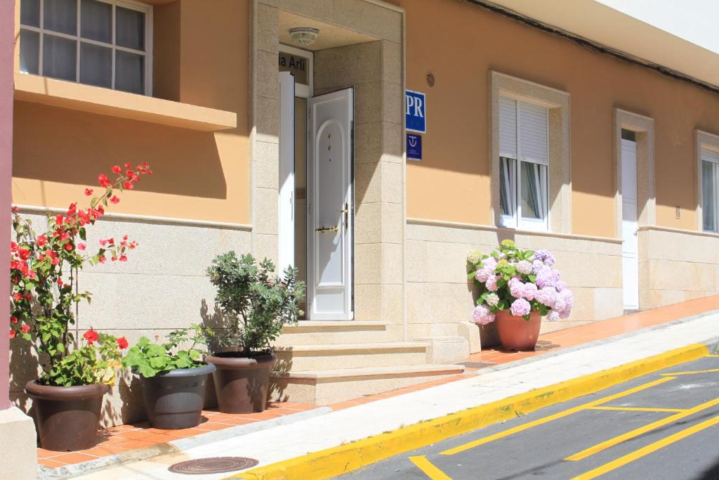 a building with potted plants on the sidewalk at Hostal Arli in San Francisco