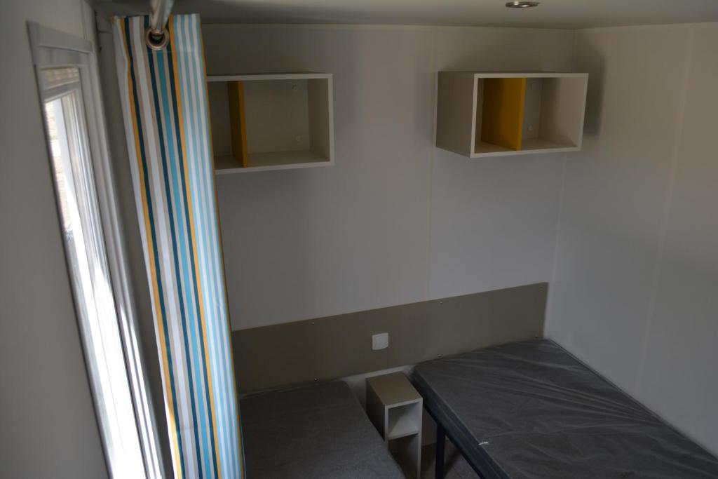 a small room with a bed and a window at Camping Valencia el Saler in El Saler