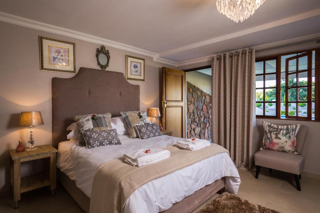 a bedroom with a large bed with towels on it at La Vida Luka - Luxury Guesthouse in Pretoria