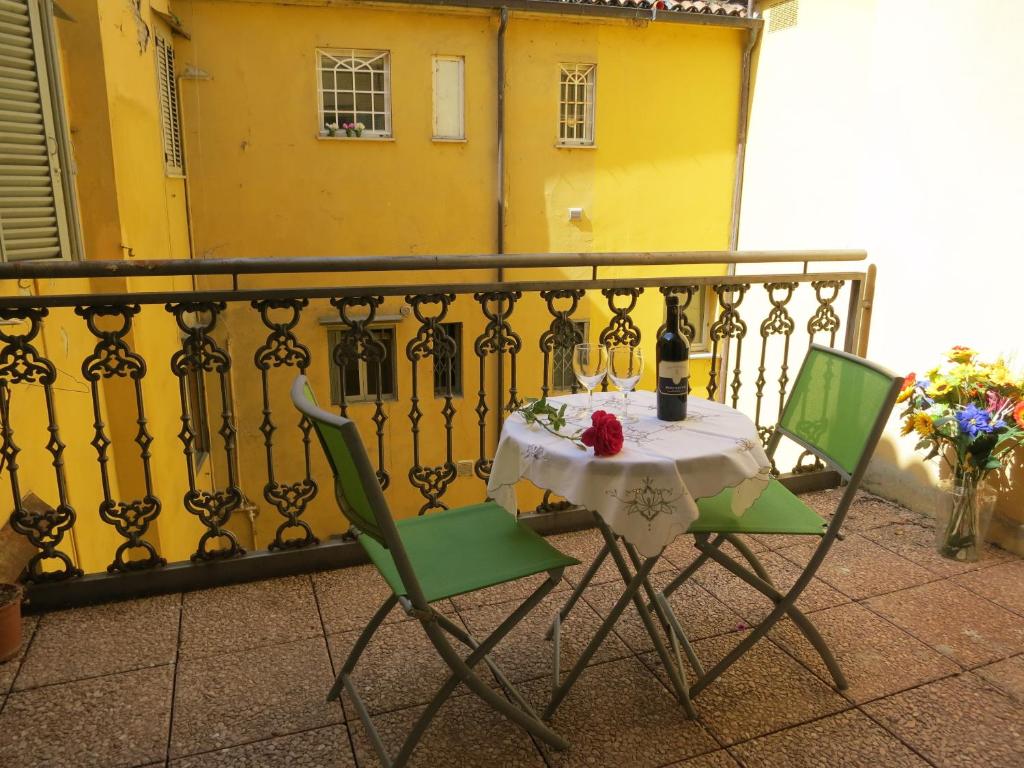 einen Tisch und Stühle auf einem Balkon mit gelbem Gebäude in der Unterkunft Casa Della Zia, Bologna by Short Holidays in Bologna